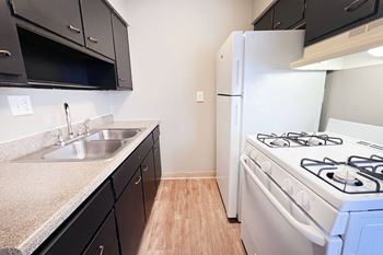 A kitchen with a white stove and black cabinets.